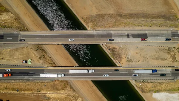An overhead view showing passenger and commercial traffic on bridges over the California Aqueduct in the heart of the Central Valley.