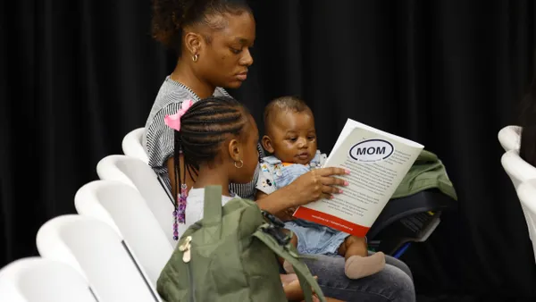 A mom sits with two children.