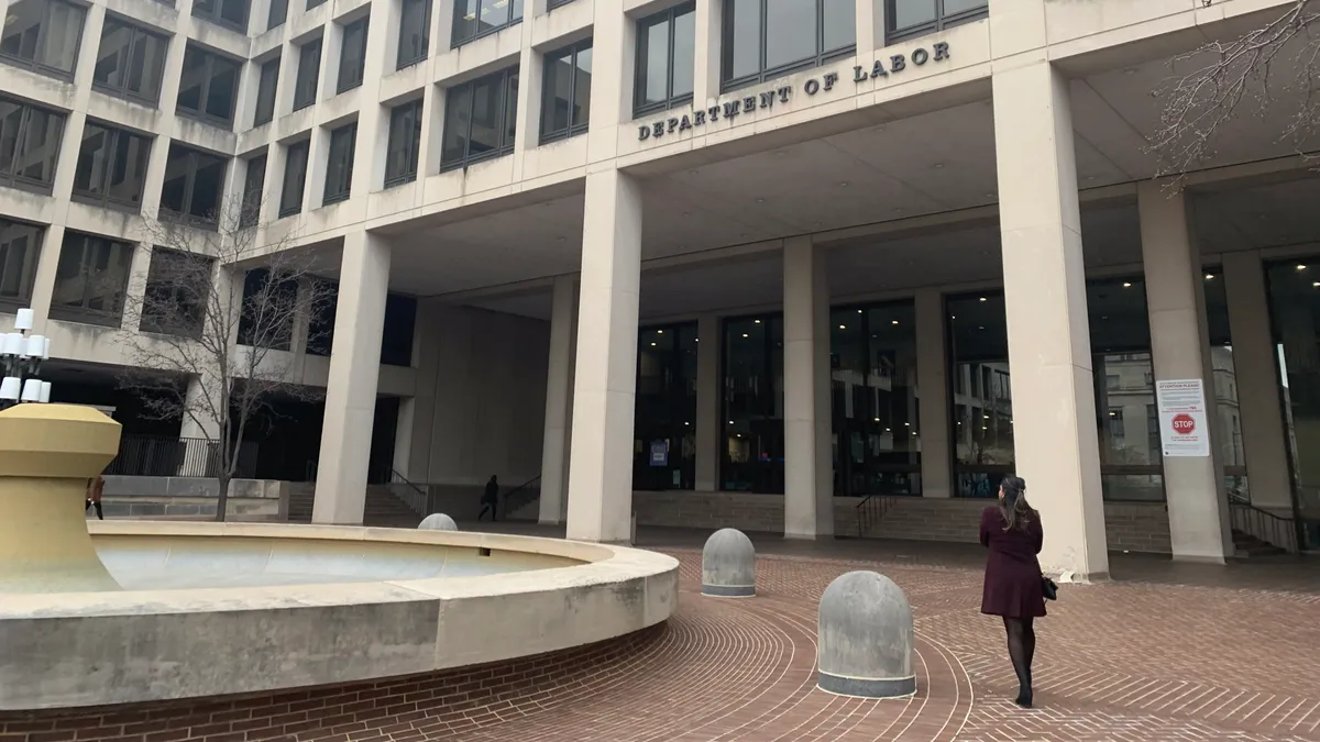 A person walks toward the door of the U.S. Department of Labor building.