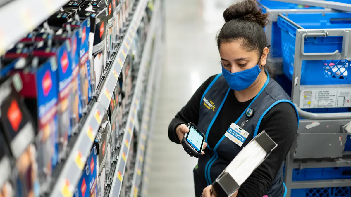 A worker in a retail store using a phone while working.