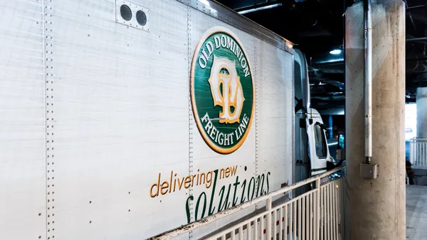 Shipping truck parked in indoors parking garage.
