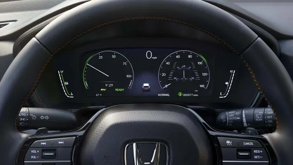 The steering wheel and instrument cluster in a 2026 Honda CR-V TrailSport Hybrid.