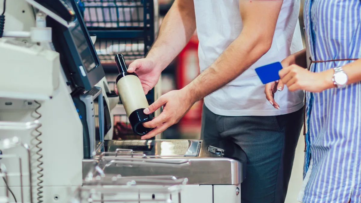 Grocery shoppers buying wine at a self-checkout station