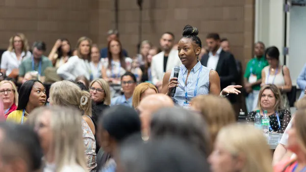 An attendee speaks into a microphone at a conference