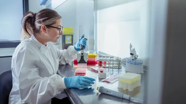 Scientist pipetting bacterial solution in laboratory
