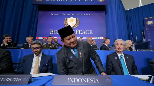 President of Indonesia Prabowo Subianto sits down among other world leaders in front of a banner that reads "Donald J. Trump Institute of Peace Board of Peace."