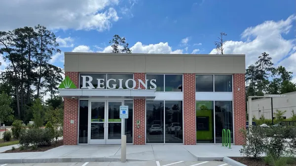 The exterior of a brick and glass building features the Regions Bank name and logo.