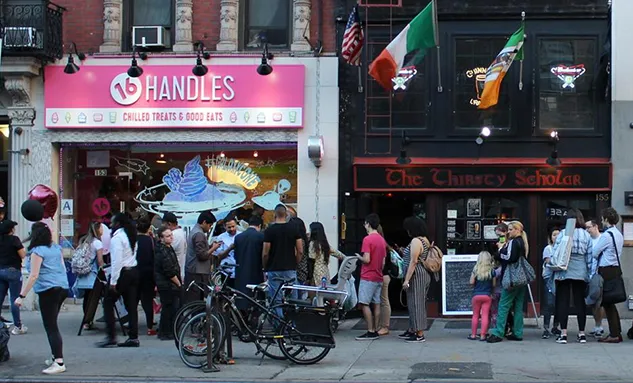 An image of a yogurt restaurant with a line of people outside.