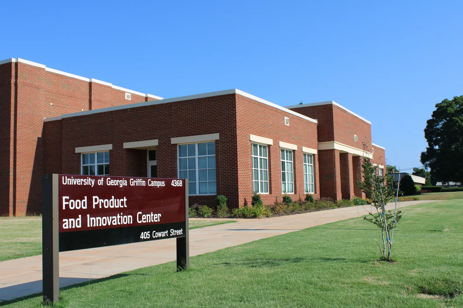 A sign reads 'University of Georgia Griffin Campus; Food Product and Innovation Center; 405 Cowart Street' outside of a brick building