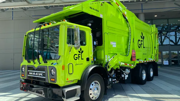 A demonstration hauler with GFL's logo outside a conference center