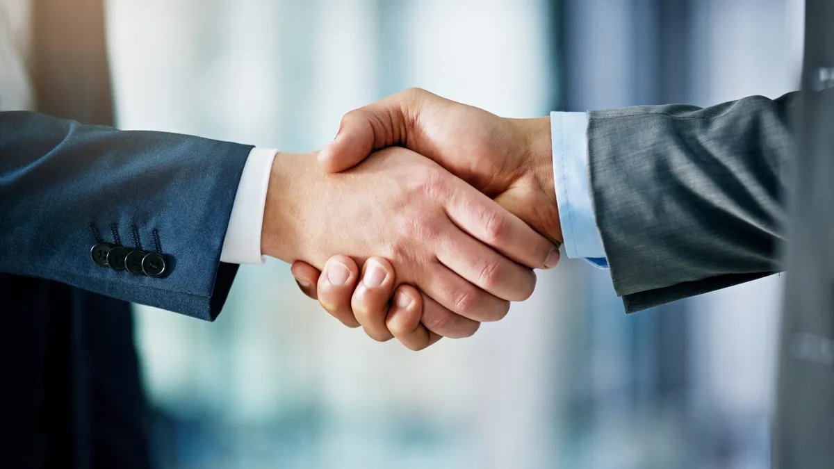 Closeup shot of two businessmen shaking hands in an office