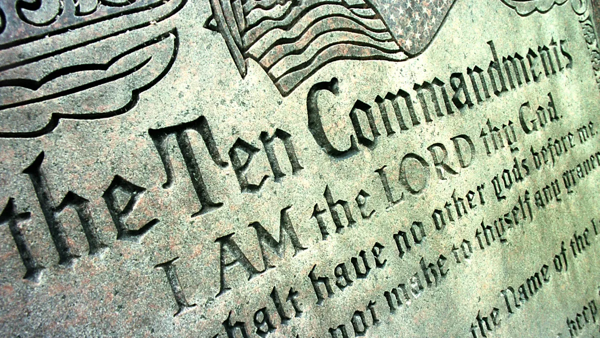 A close up view of a sculpture reads "the Ten Commandments. I am the LORD thy God."