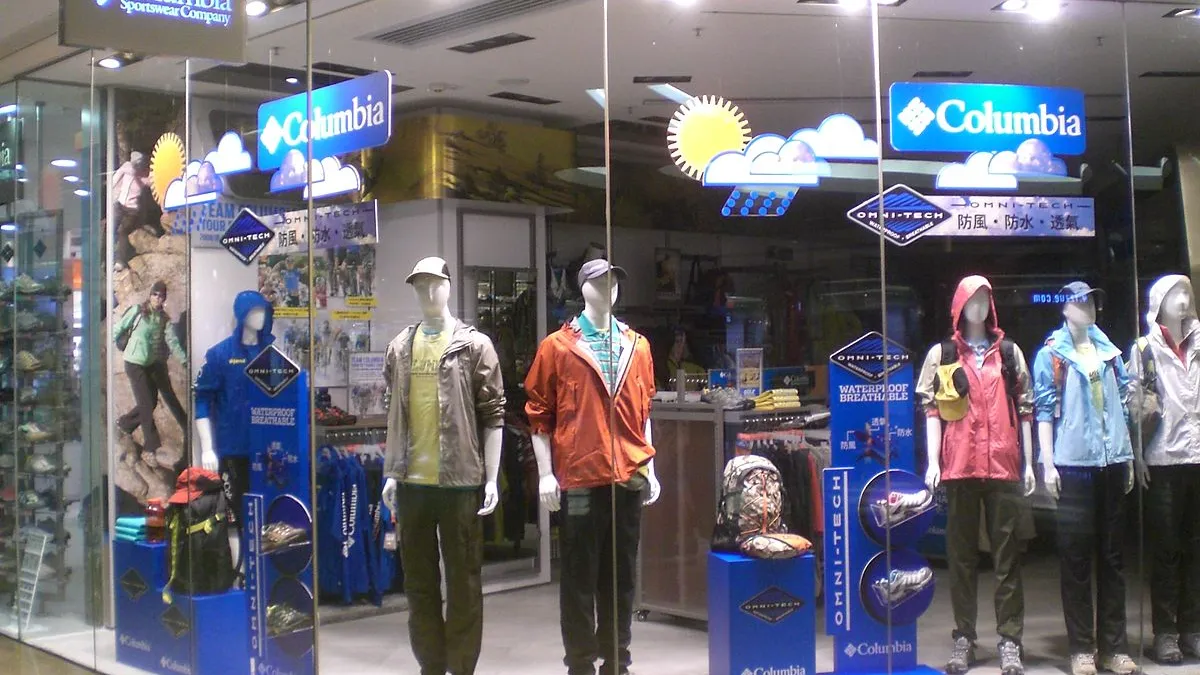 A Columbia Sportswear store front is pictured through a window, showing mannequins in outdoor wear.