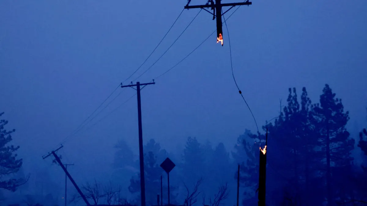 Fire damaged power lines are viewed at dawn during the Bridge Fire in Wrightwood, California.