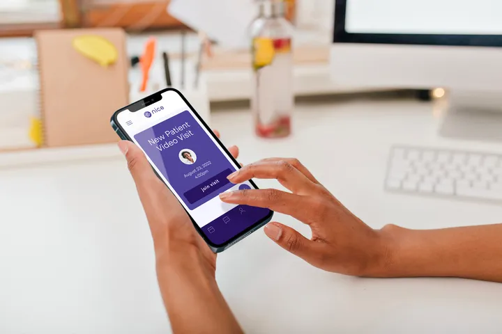 A person using the Nice Healthcare app on their phone.