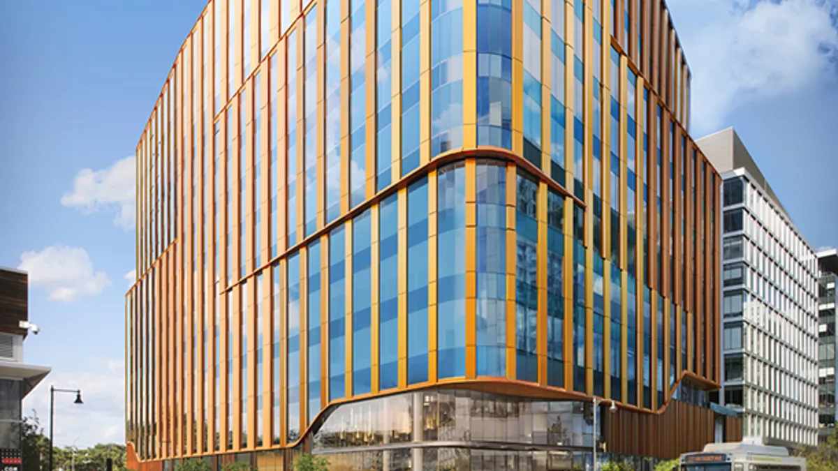 A rendering of a wood and glass building with a rounded facade on a street corner.