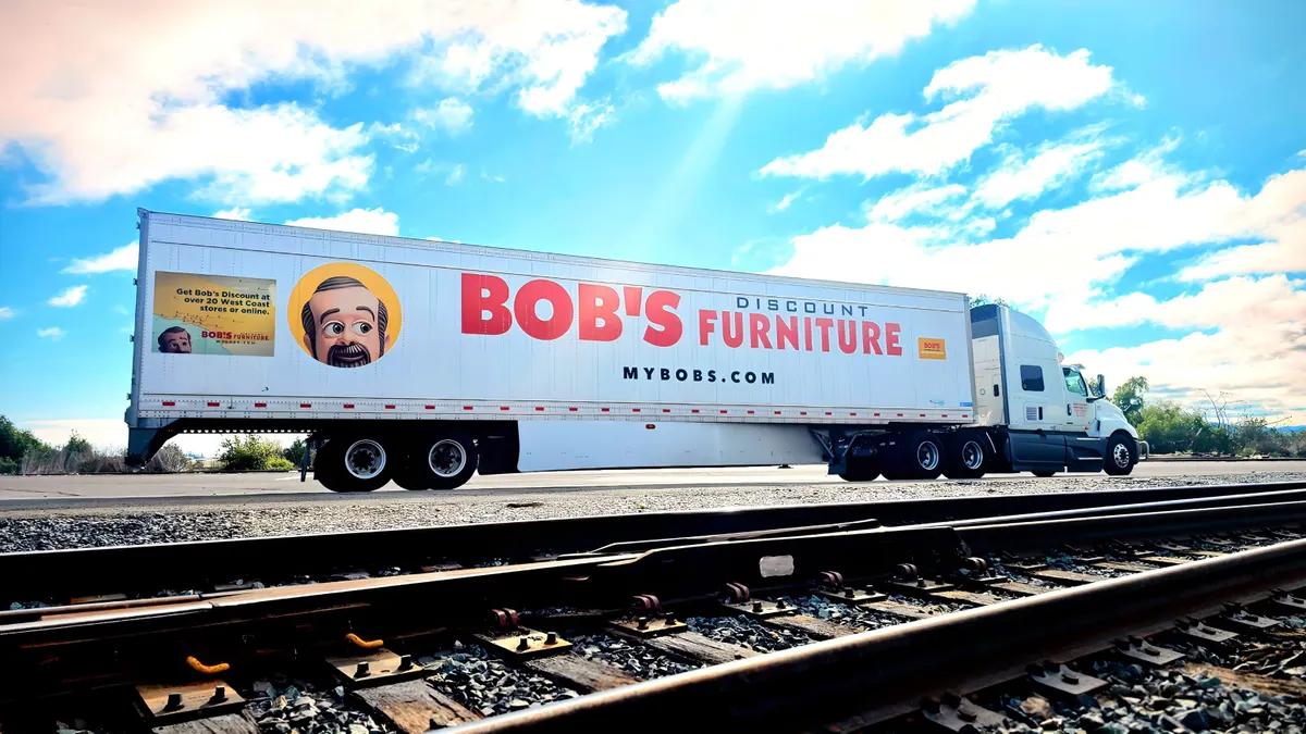 A freight truck with a Bob's Discount Furniture logo and mascot.