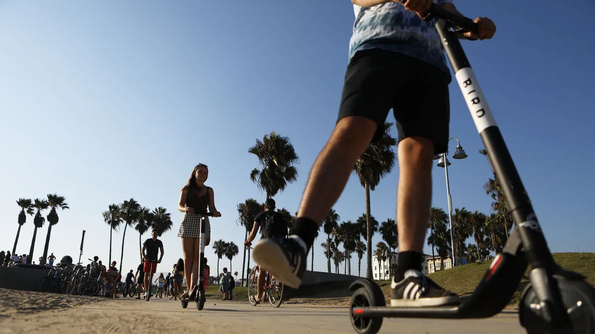 A photo of people riding Bird scooters.