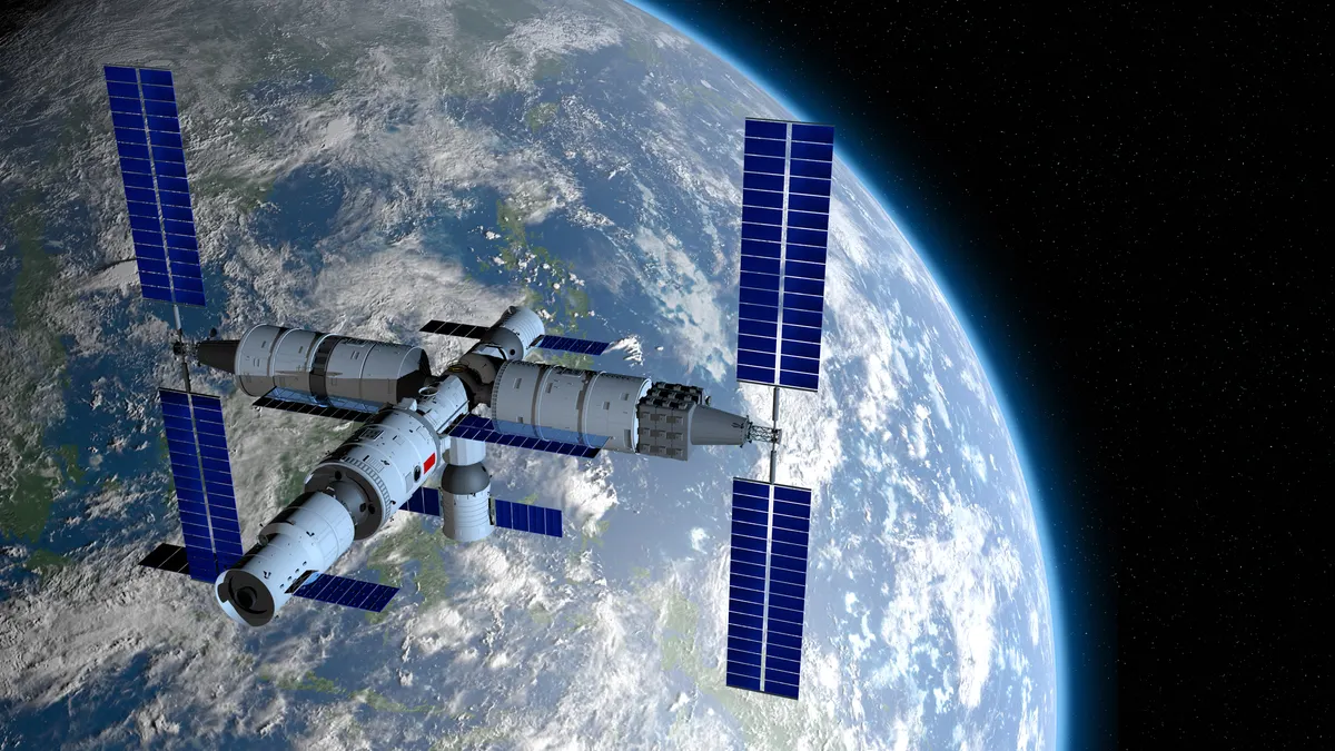 China's Tiangong Space Station orbits Earth in space against a starry background.