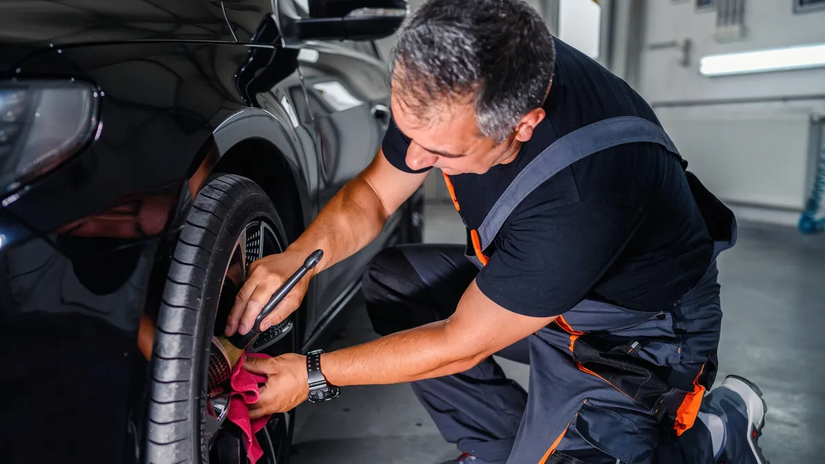 A professional car service worker polishing a luxury car