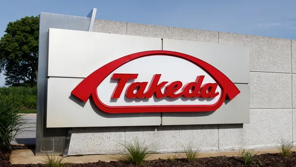 A sign with the logo for the Takeda pharmaceutical company.