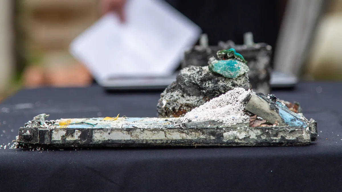 A damaged lithium-ion battery is displayed on a table.