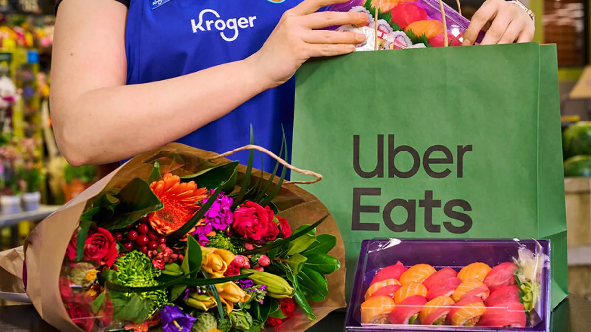 Close-up of a Kroger worker with a bouquet and Uber Eats bag