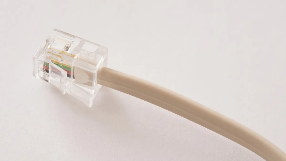 Clear plastic telephone plug or jack and cable over a white background with copy space