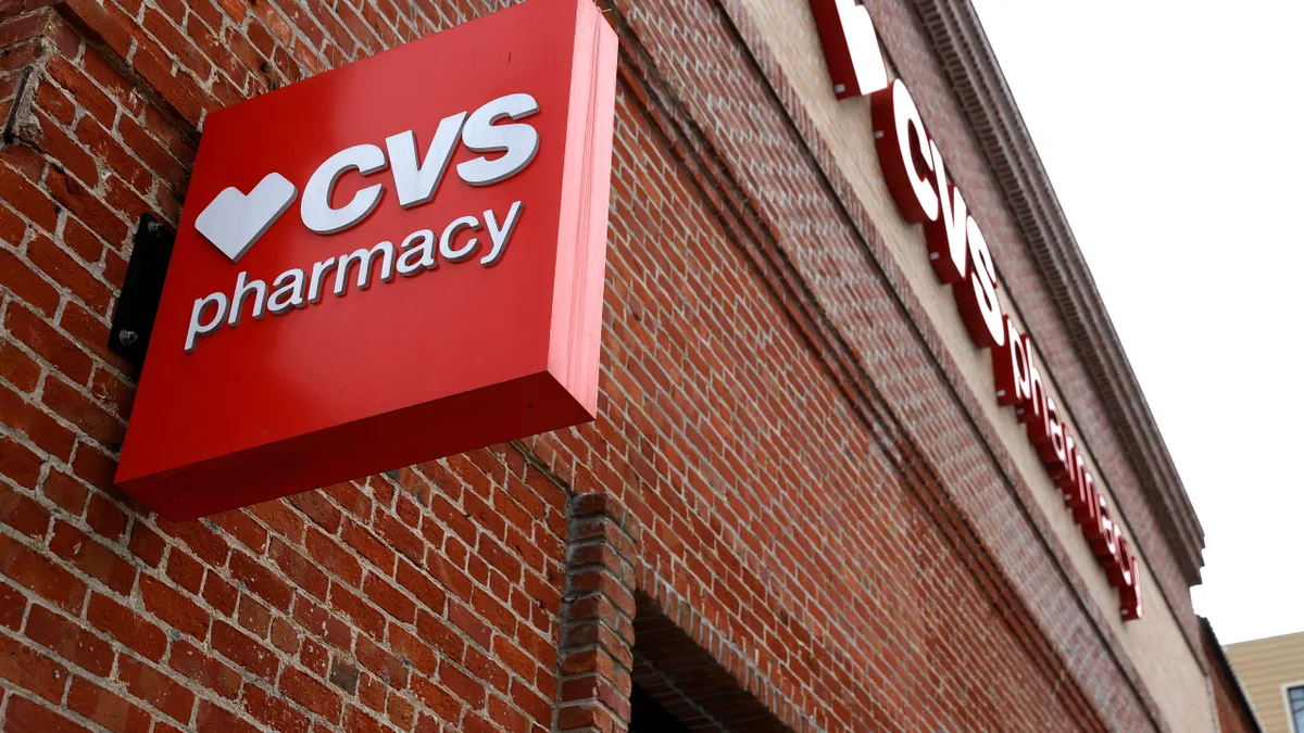 A brick wall with a red CVS Pharmacy sign.