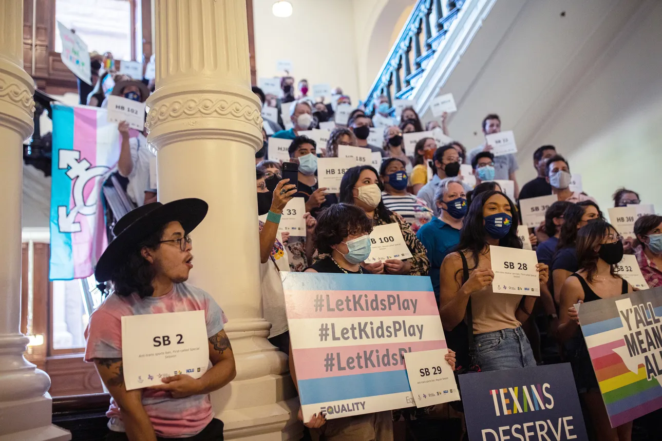 Students stand with signs in support of LGBTQ+ rights