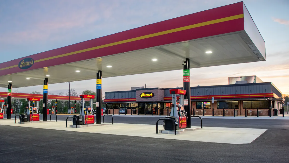 A photo of the exterior of a gas station and convenience store. The canopy, the gas pumps and a sign on the store all say "Rutter's."