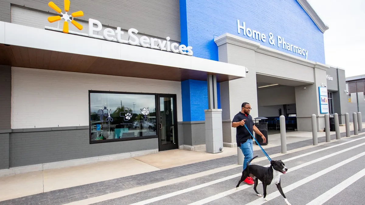 Person walking their dog outside of Walmart's Pet Services center.