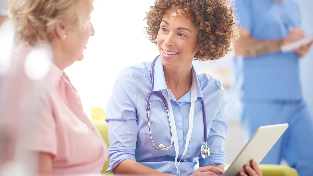 A health practitioner speaking with a patient and smiling