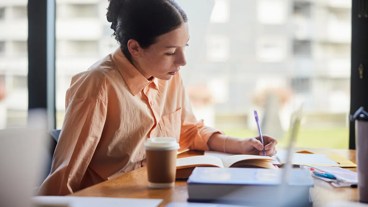 student writing down notes