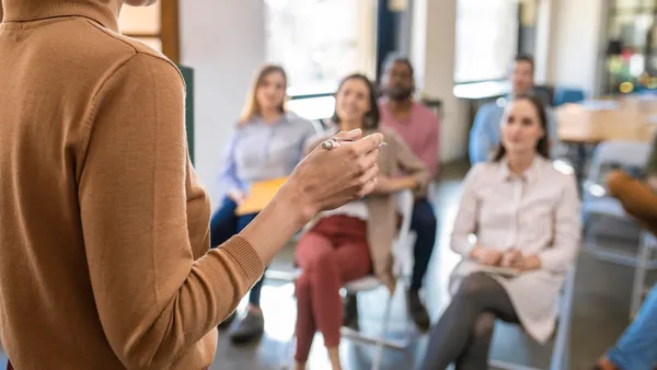 A person gives a lecture to a group of people.