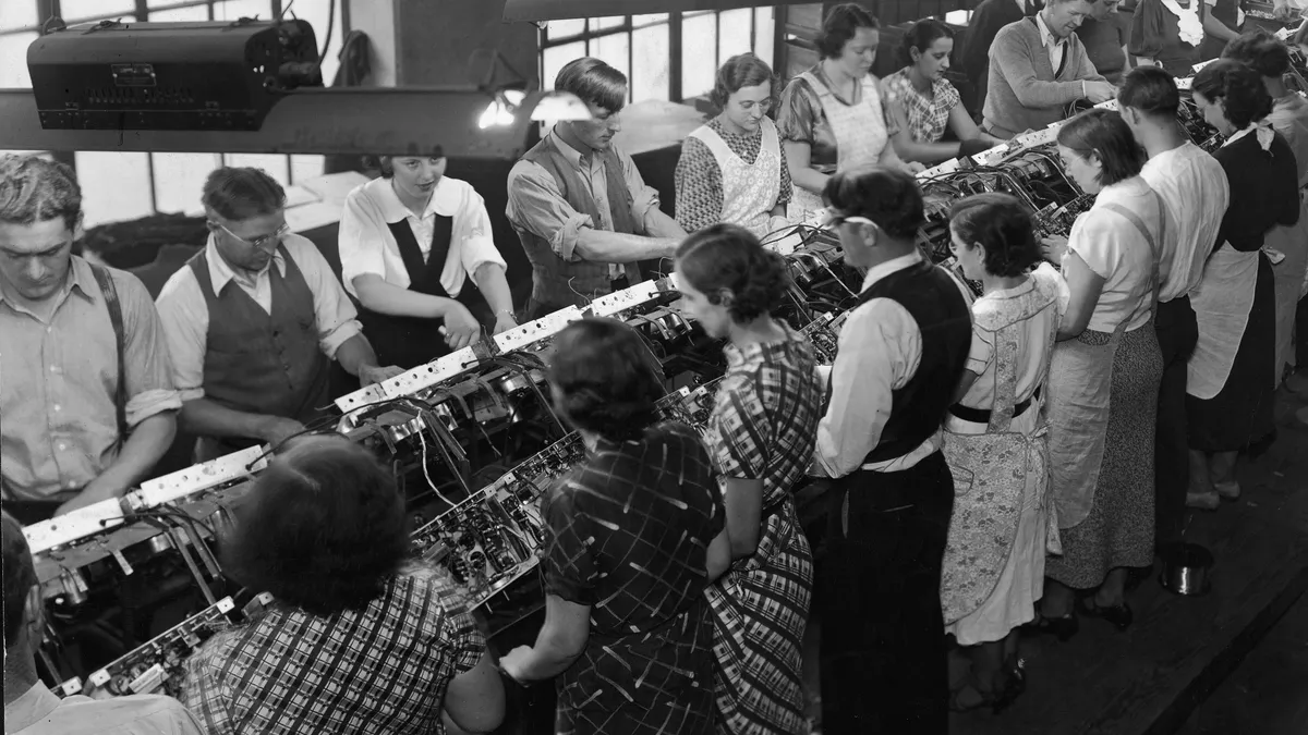 Workers of all genders work along a conveyor belt