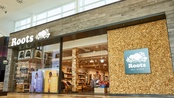 A Roots storefront inside a mall, with cork and wood detailing.