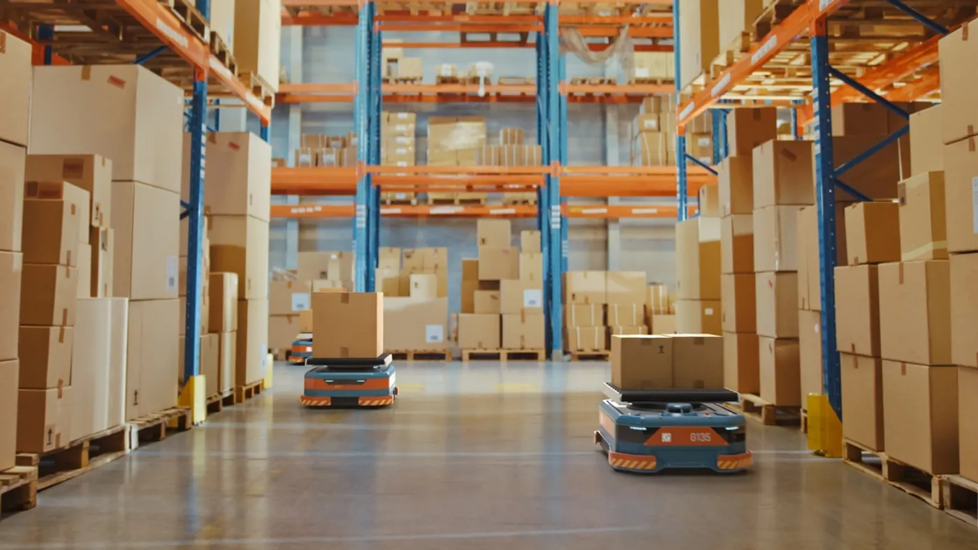 Boxes stacked up on multiple metal shelves in a warehouse setting.