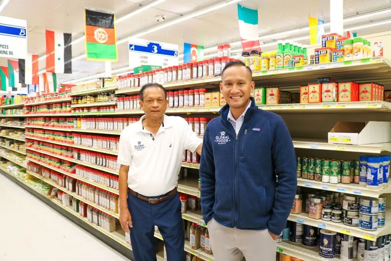 Adult man and his father standing next to each other in a grocery store aisle