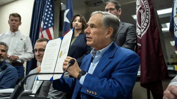 Texas Gov. Greg Abbott signs a proclamation during a press conference.