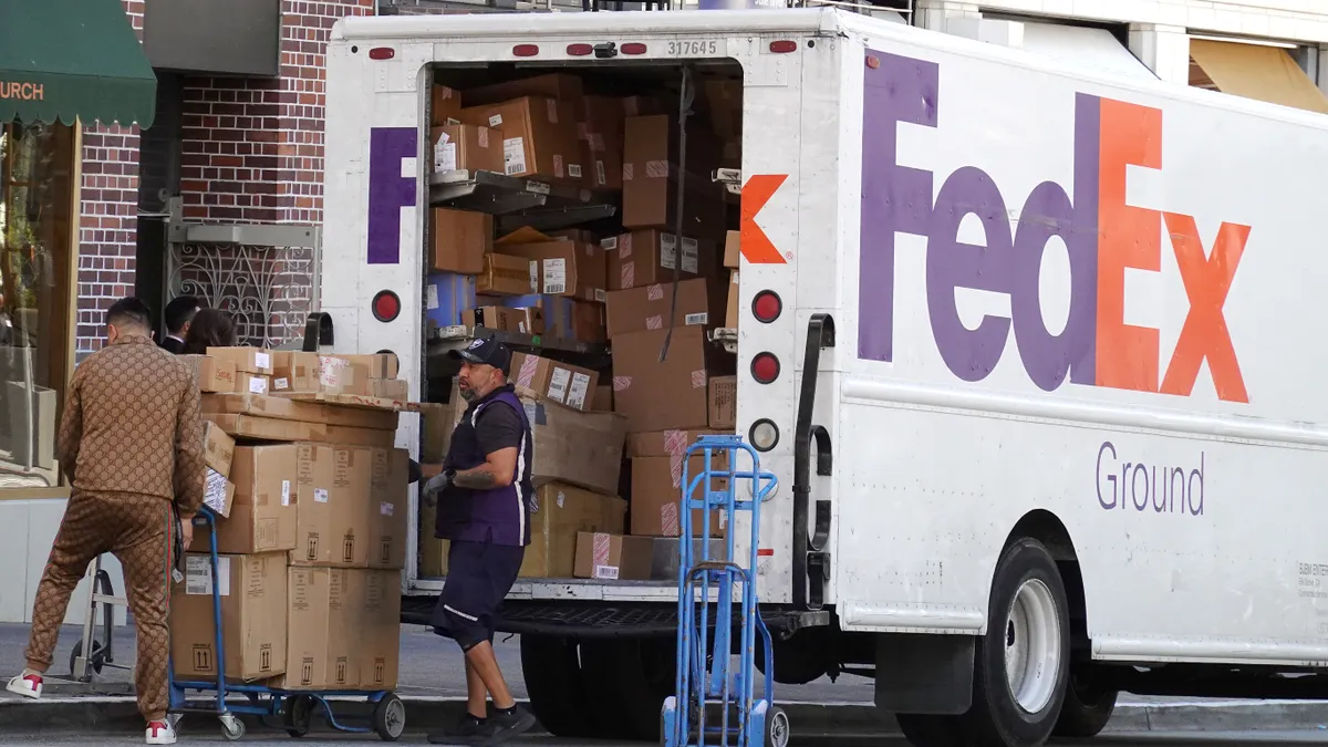 A worker loads packages into a FedEx truck on June 20, 2023 in San Francisco, California.