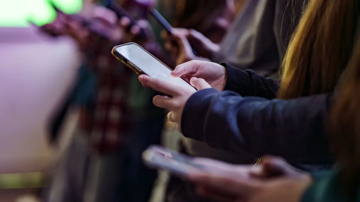 A close-up view of students holding cellphones while at school.