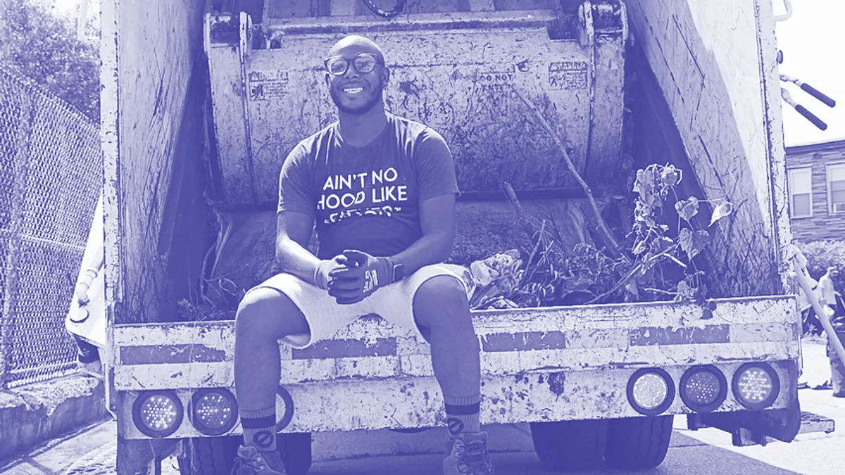 Terrill Haigler sits on the back of a trash truck