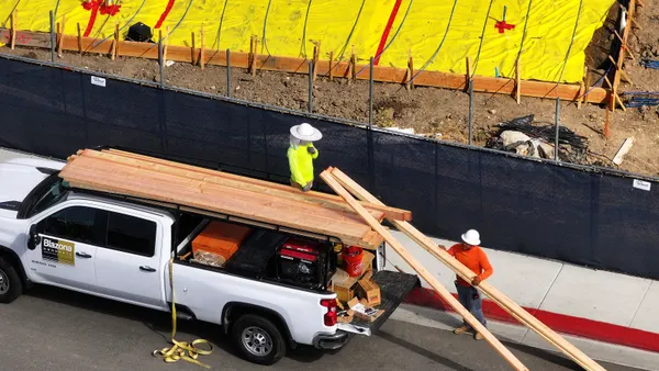construction workers unloading lumber on July 1, 2025, in Hercules, Calif.