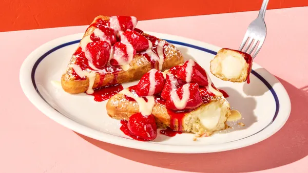 An order of Stuffed French Toast topped with strawberries and oozing sweet cream.