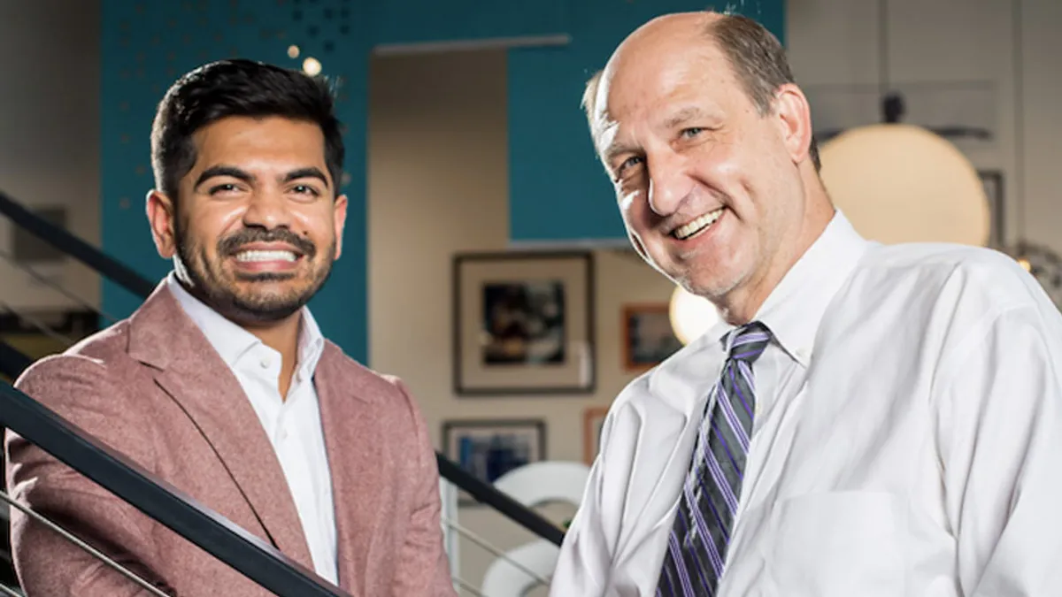 Two individuals, Mountain Express’ former co-CEOs, standing on a stairway for a portrait.