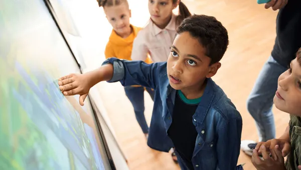 Boy looking at the interactive whiteboard with eyes wide open.