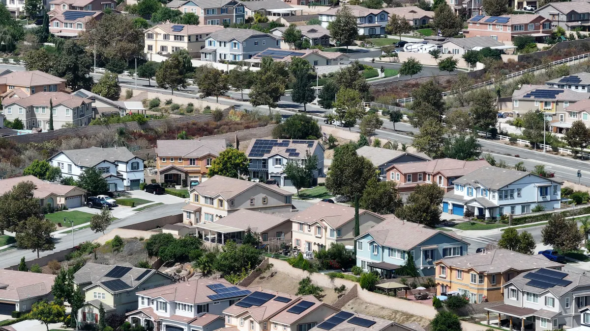 An aerial view of residential homes, many with solar panels.