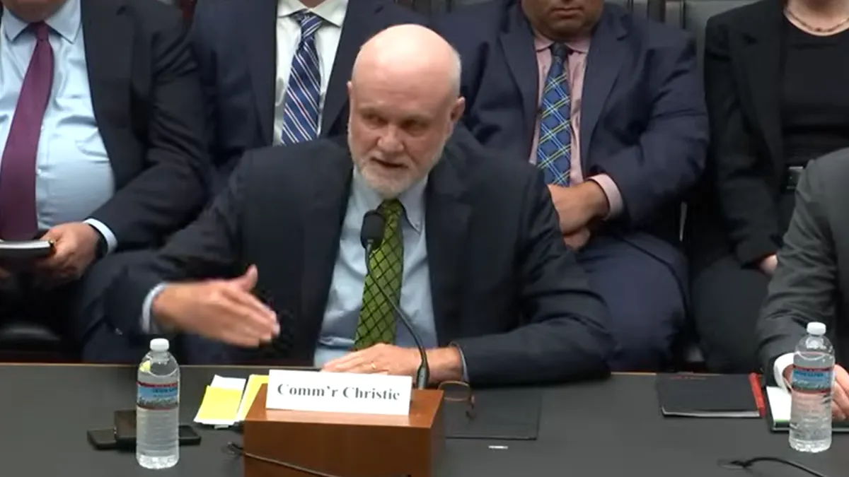 A man speaking at a desk.