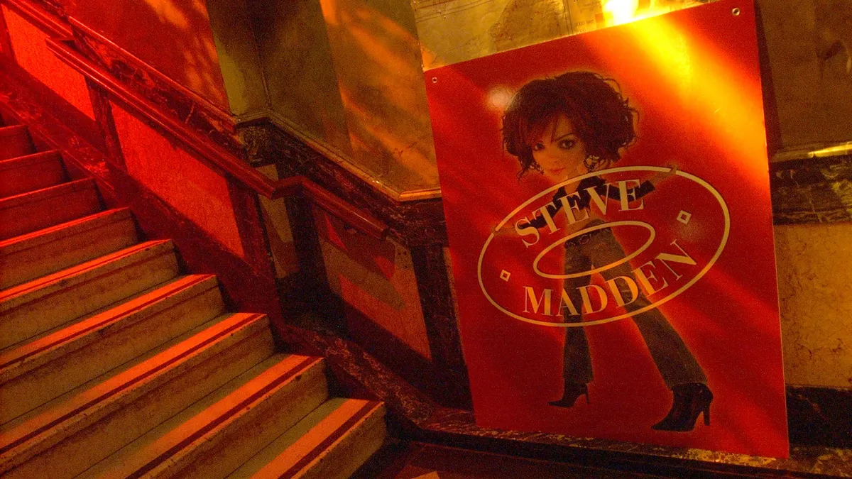 Red-lit steps and Steve Madden signage at a rock club during an event.